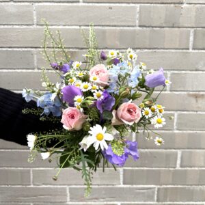 Ein tänzelnder Strauß aus zarten Frühsommerblumen wie Margeriten, Kamille, Glockenblume, Wicke und Rittersporn kommt doch überall gut an. Die feinen Blumen verleihen dem Strauß seine aufgelockerte Wirkung und die pastellenen Farben bringen die Leichtigkeit. Von klein und fein bis mittelgroß – dieser, eher kurz gebundene Strauß, eignet sich besonders gut für den Esstisch und bringt zugleich einen leichten Duft mit. „Frühsommergefühle“ – noch nicht ganz Sommer, aber bald!